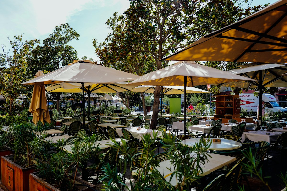 A terrace of tables under big umbrellas