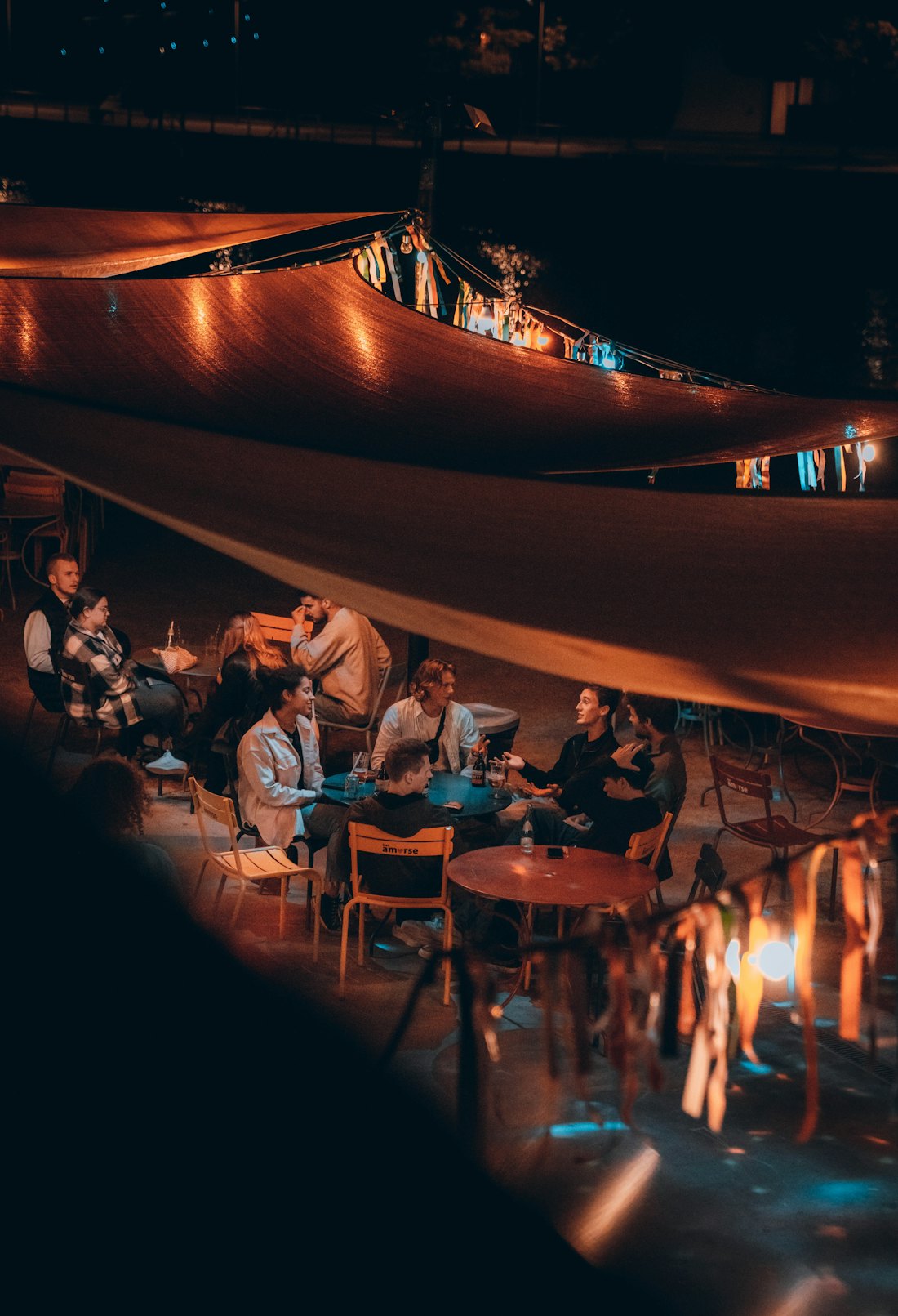 A busy, warmly lit restaurant full of people at their tables